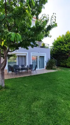 a house with chairs and a tree in a yard at Urbi Garden in Artemida