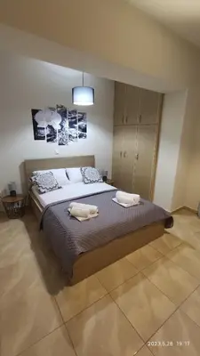 a bedroom with a large bed with two towels on it at Urbi Garden in Artemida