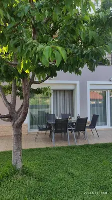 a table and chairs under a tree in a yard at Urbi Garden in Artemida