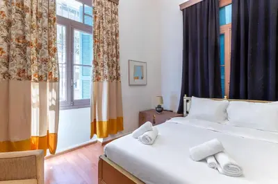 a bedroom with a large bed with towels on it at 4 Bedroom Vintage House in heart of Pagrati Athens in Athens