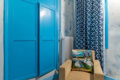 a blue room with a chair and a window at 4 Bedroom Vintage House in heart of Pagrati Athens in Athens