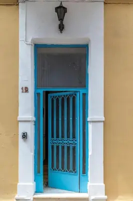 a blue door on a building with a window at 4 Bedroom Vintage House in heart of Pagrati Athens in Athens