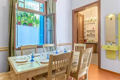 a dining room with a table and chairs and a window at 4 Bedroom Vintage House in heart of Pagrati Athens in Athens