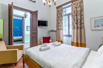 a bedroom with a large white bed and a window at 4 Bedroom Vintage House in heart of Pagrati Athens in Athens