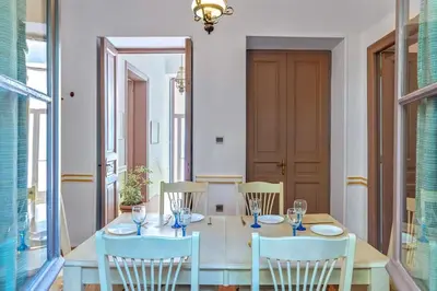 a dining room with a wooden table and chairs at 4 Bedroom Vintage House in heart of Pagrati Athens in Athens