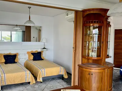 a bedroom with two beds and a wooden cabinet at Stunning View Seaside 1-Bed Apartment in Saronida in Saronida