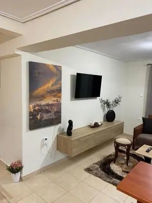 a living room with a flat screen tv on the wall at Garden View Apartment in Athens