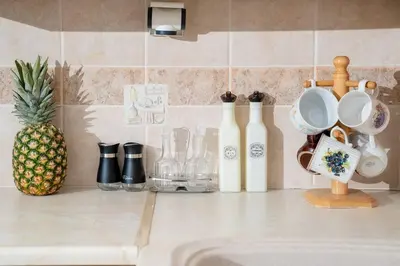 a kitchen counter with a sink with cups and a pineapple at Omnia Maisonette by A&D Properties in Porto Rafti