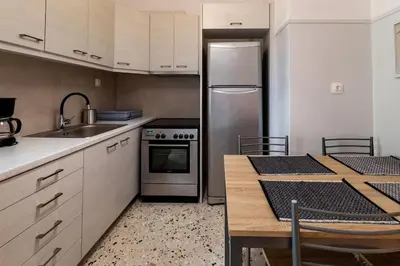 a kitchen with a stainless steel refrigerator and a table at The Athenian Hideaway 2- Bedroom apartment in Thiseio in Athens