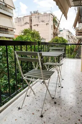a chair sitting on a balcony next to a fence at The Athenian Hideaway 2- Bedroom apartment in Thiseio in Athens