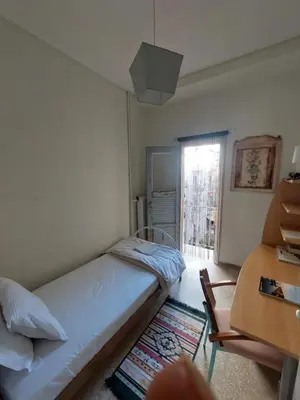 a bedroom with a bed and a desk and a window at Retro Stay Athens in Athens