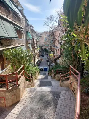 an alley with benches and a street with buildings at Retro Stay Athens in Athens