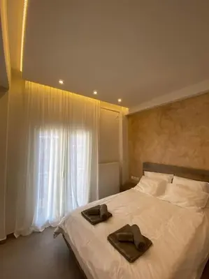 a bedroom with a bed with two brown towels on it at Piraeus cozy appartment rental in Piraeus