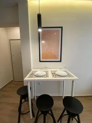 a white table with two chairs and a picture on the wall at Piraeus cozy appartment rental in Piraeus