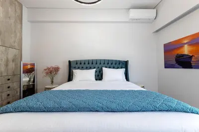 a bedroom with a large bed with a blue blanket at Luxury flat at archaeological museum in Athens