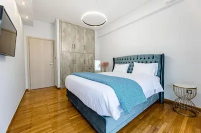 a bedroom with a large bed and a television at Luxury flat at archaeological museum in Athens