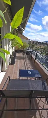a balcony with tables and benches on a building at LView Zeus Temple in Athens