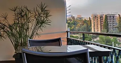 a table and chairs on a balcony with a view at LView Zeus Temple in Athens