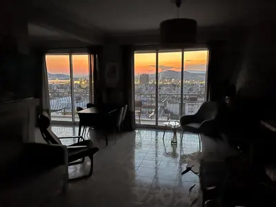 a living room with a view of a city from the window at Porto Pireo Penthouse Sea View in Piraeus