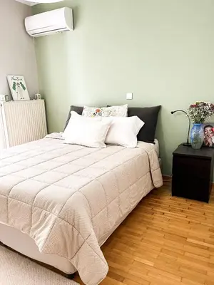 a bedroom with a bed with white sheets and a lamp at Porto Pireo Penthouse Sea View in Piraeus