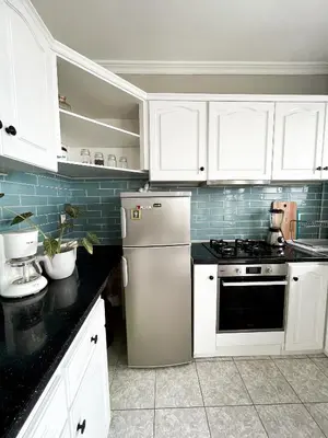a kitchen with white cabinets and a refrigerator at Porto Pireo Penthouse Sea View in Piraeus