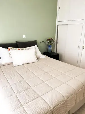 a bedroom with a large bed with a white comforter at Porto Pireo Penthouse Sea View in Piraeus