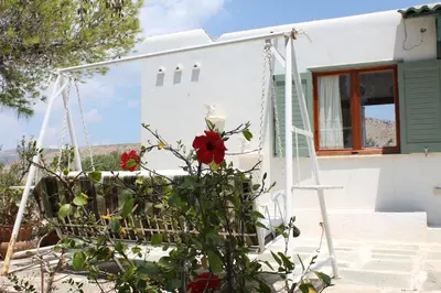 a swing in front of a house with red roses at Aegean traditional home in Athens Riviera in Sounio