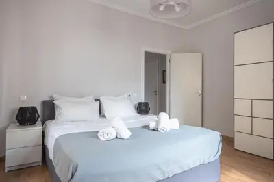 a white bedroom with a large bed with towels on it at Syntagma SQ Residence in Athens