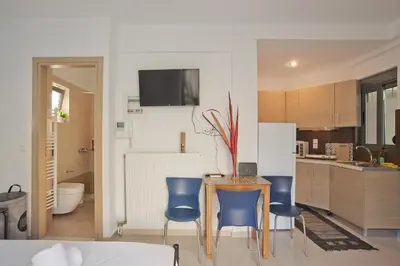 a kitchen with a table and two blue chairs at Glyfada Cozy Studio, WiFi, AC in Athens