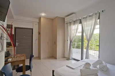 a bedroom with a bed and a desk and a window at Glyfada Cozy Studio, WiFi, AC in Athens