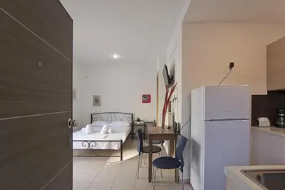 a kitchen with a table and a white refrigerator at Glyfada Cozy Studio, WiFi, AC in Athens