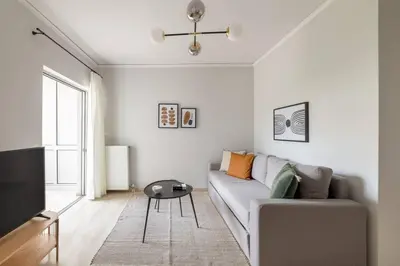 a living room with a couch and a tv at Smart Chic 1BR Apartment in Agia Paraskevi by UPSTREET in Athens