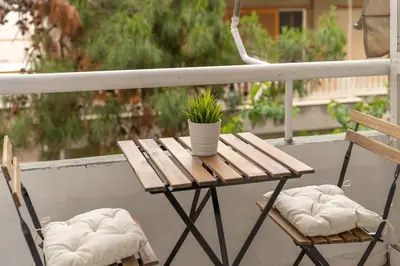 a wooden table with a potted plant on a balcony at Smart Chic 1BR Apartment in Agia Paraskevi by UPSTREET in Athens