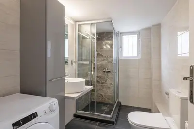 a bathroom with a shower and a toilet and a sink at Smart Chic 1BR Apartment in Agia Paraskevi by UPSTREET in Athens