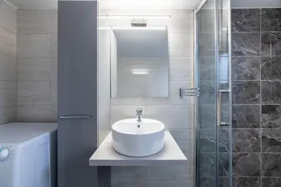 a white bathroom with a sink and a shower at Smart Chic 1BR Apartment in Agia Paraskevi by UPSTREET in Athens