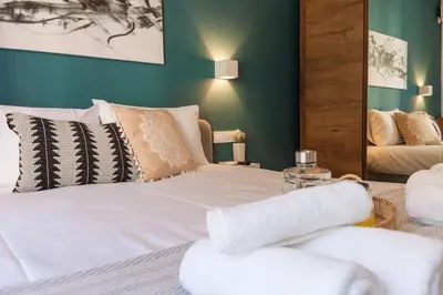 a bedroom with a bed with white sheets and pillows at Deluxe Urban 2BR Apt by Nat. Archaelogical Museum in Athens