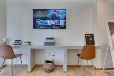 a desk with two chairs and a television on the wall at Deluxe Urban 2BR Apt by Nat. Archaelogical Museum in Athens