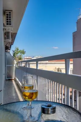 a glass of wine sitting on a table on a balcony at Deluxe Urban 2BR Apt by Nat. Archaelogical Museum in Athens