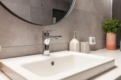 a bathroom sink with a faucet and a mirror at Deluxe Urban 2BR Apt by Nat. Archaelogical Museum in Athens