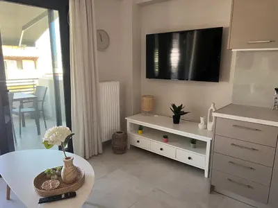 a living room with a table and a tv on the wall at Elia's Apartment in Athens