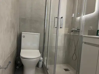 a bathroom with a toilet and a glass shower at Elia's Apartment in Athens