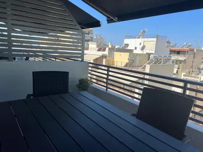 a balcony with a table and two chairs on a roof at Elia's Apartment in Athens