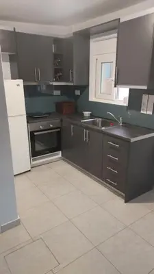 a kitchen with black cabinets and a white tile floor at studio-02 in Metókhi