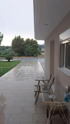 a patio with two chairs and a table and a street at studio-02 in Metókhi