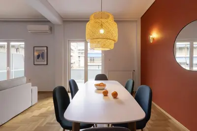a dining room with a white table and chairs at A new happy 2 BDR apartment that has a soul in Athens