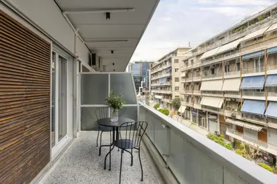 a balcony with a table and chairs on it at A new happy 2 BDR apartment that has a soul in Athens