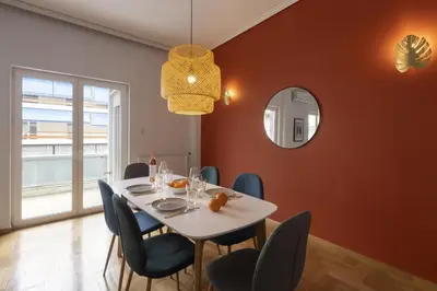 a dining room with a white table and blue chairs at A new happy 2 BDR apartment that has a soul in Athens