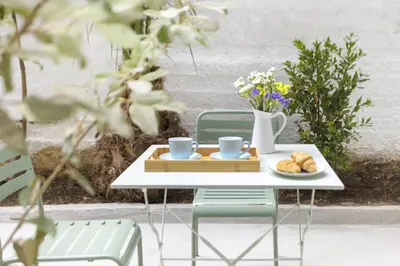 a table and chairs with a tray of food on it at AnapironPolemou5 - Elegance meets charm in a posh in Athens