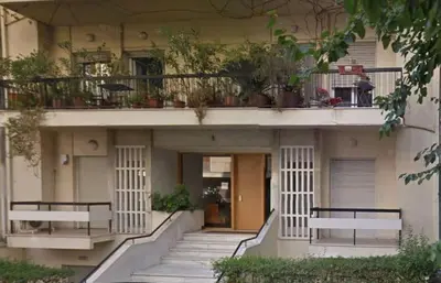 a building with two benches and a balcony with plants at AnapironPolemou5 - Elegance meets charm in a posh in Athens