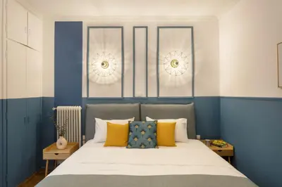 a bed with blue and white walls and yellow pillows at AnapironPolemou5 - Elegance meets charm in a posh in Athens